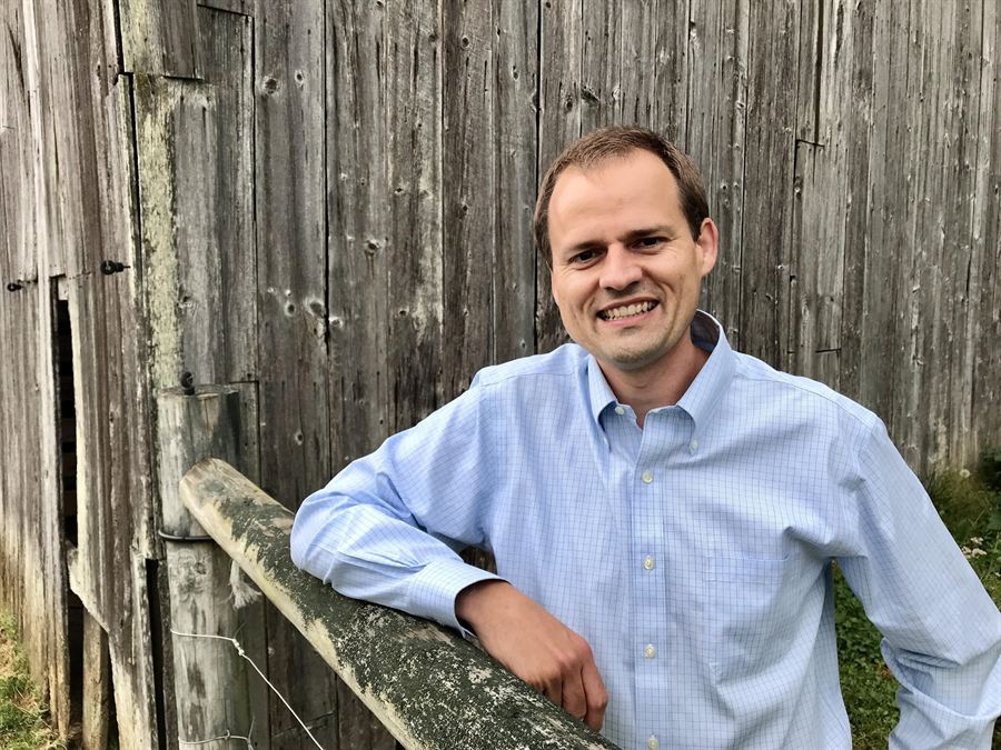 Matthew Falk, CFA, beside a barn